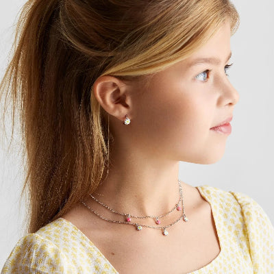 Meisje met kindersieraden zoals een ketting en oorbelletjes.