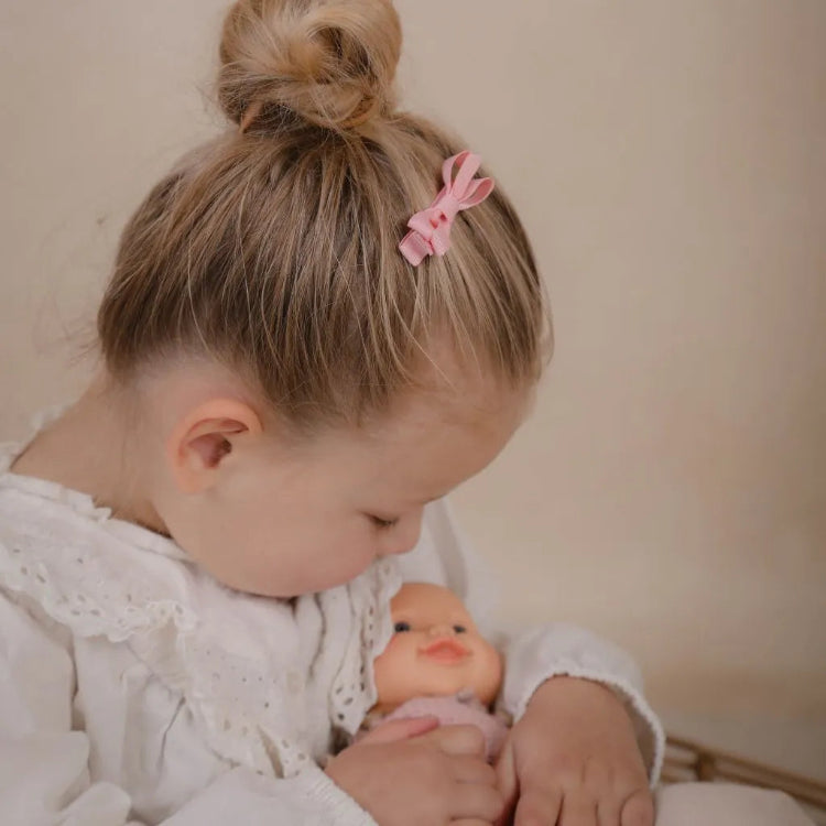 Kleutermeisje met roze strik haarspeldje in het haar.