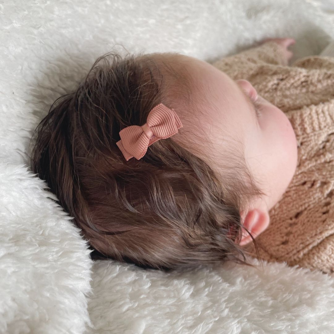 baby meisje met een klein babyhaarspeldje met strikje in het haar.