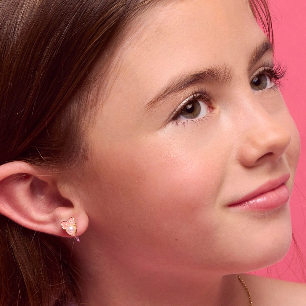 Meisje met een lief setje kinder clip oorbellen voorzien van een strikje en een pareltjes