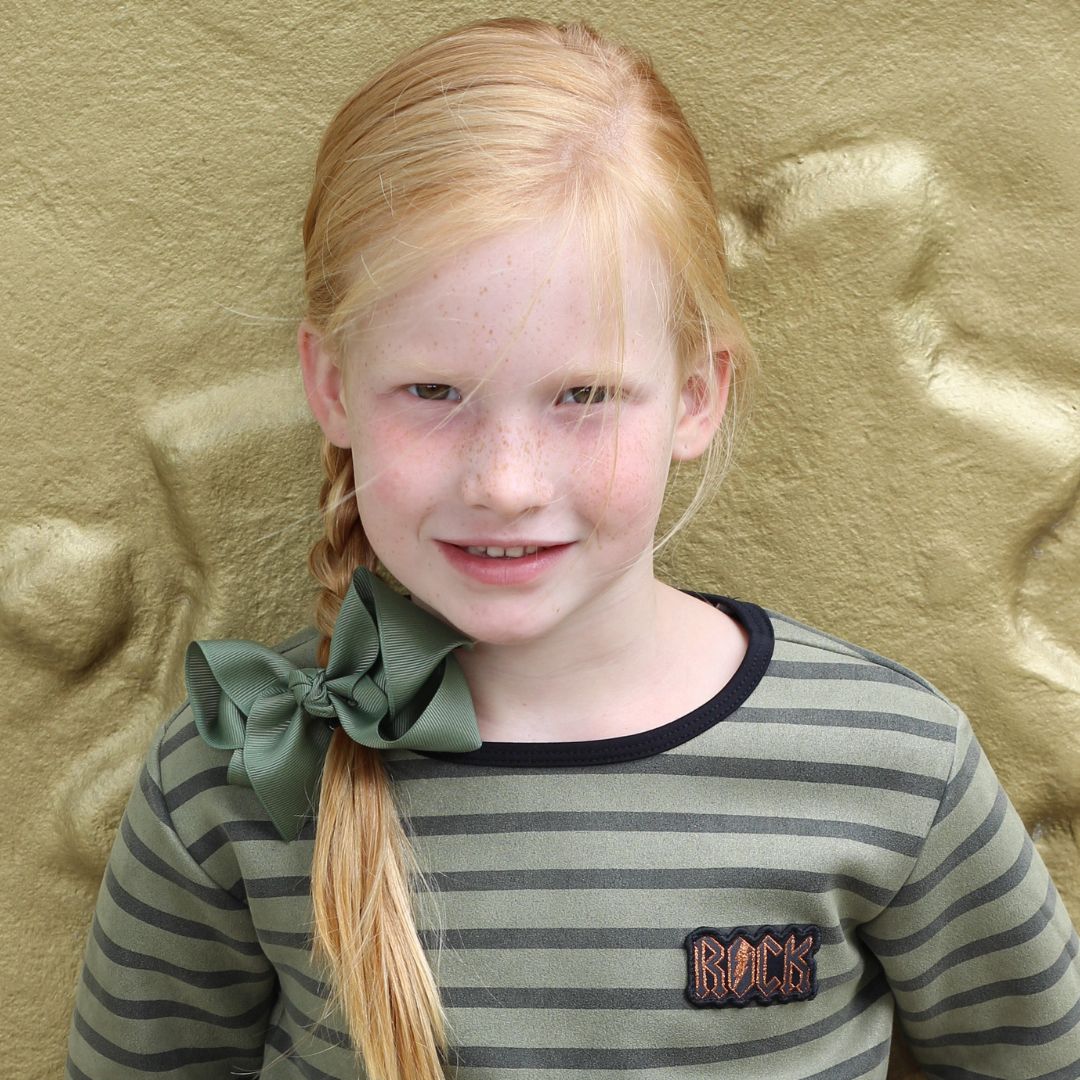 Meisje met de extra grote haarstrik in de kleur mosgroen in het haar